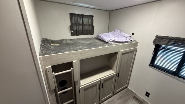 RV bunk bed with built-in ladder, storage cabinets, and sleeping space
